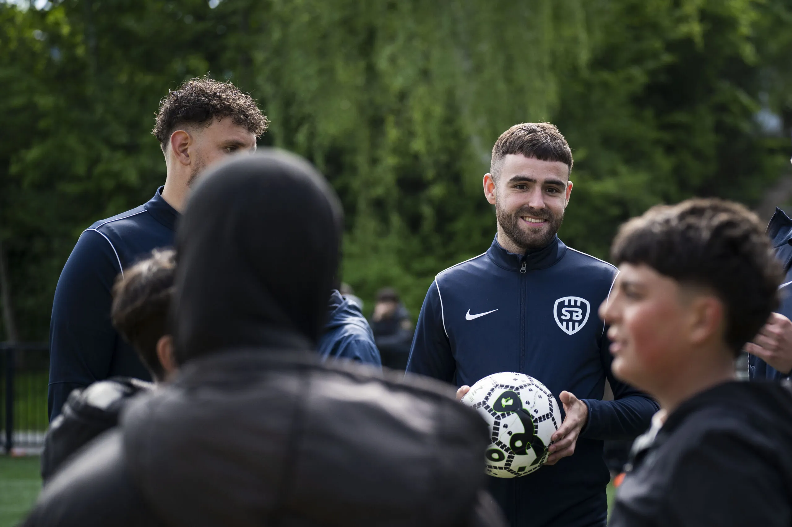 Trainers op een voetbalveldje