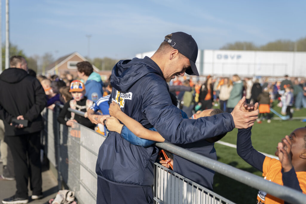 Jongens die high five geven aan de buurtsportcoach