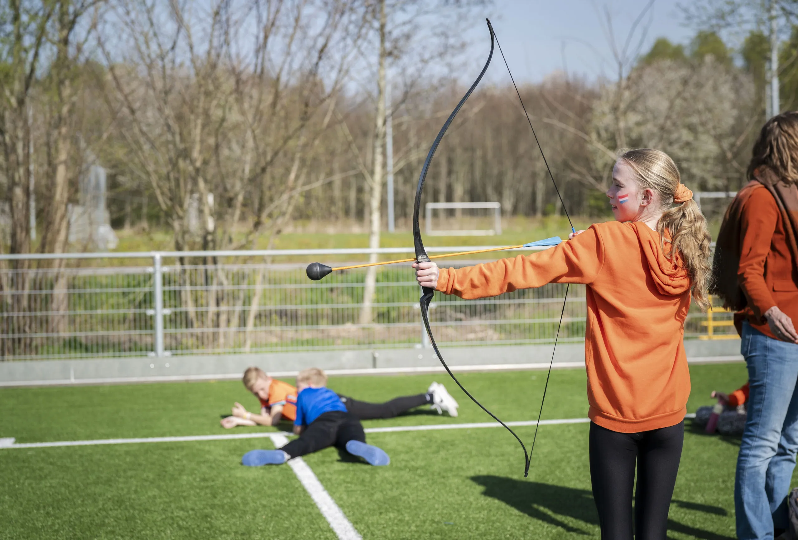 Meisje speelt archery tag op het sportveld