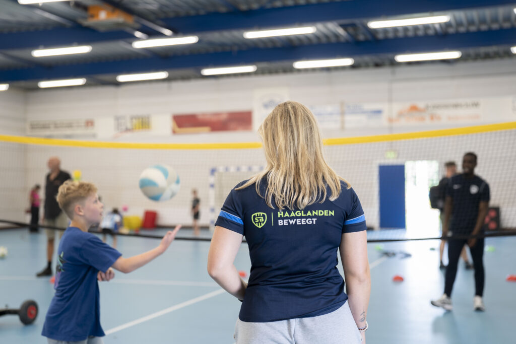 Coach die kinderen leert volleyballen