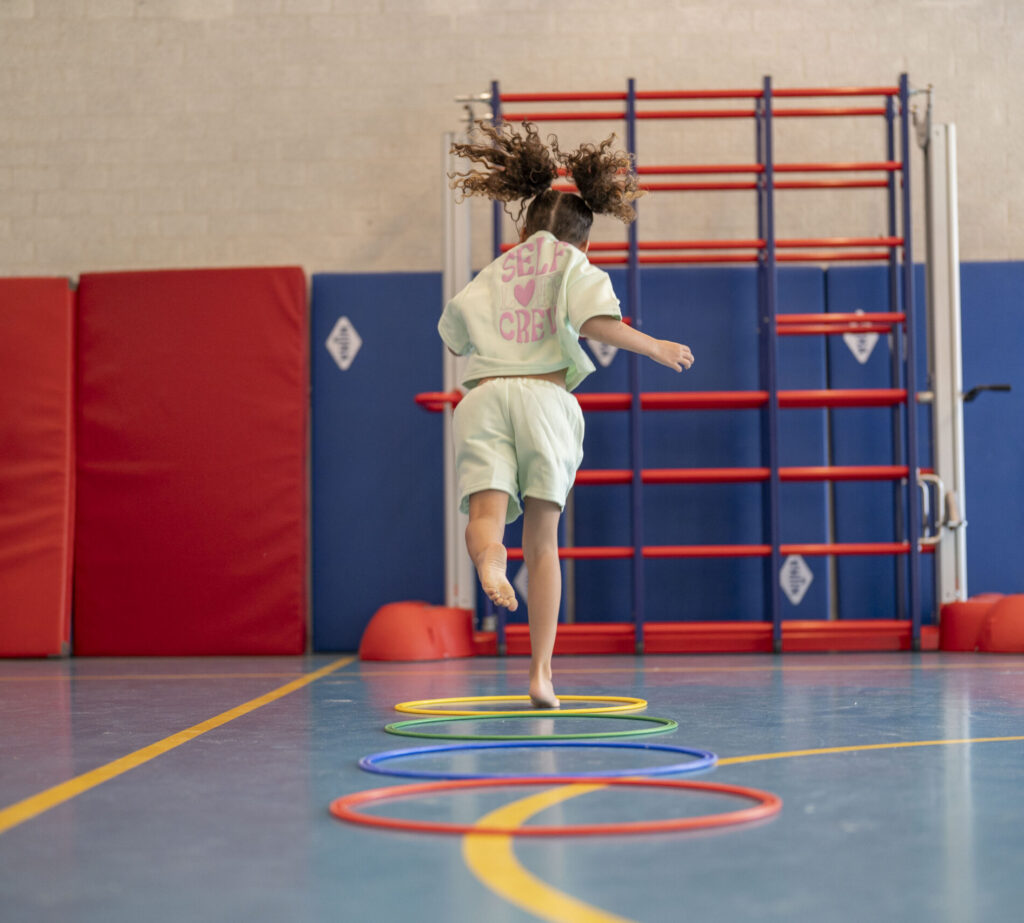 Meisje dat door hoepels springt in de gymzaal