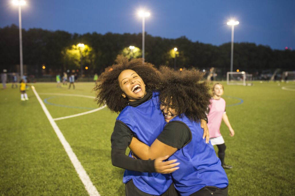 Teamgenoten die elkaar omhelzen op het voetbalveld