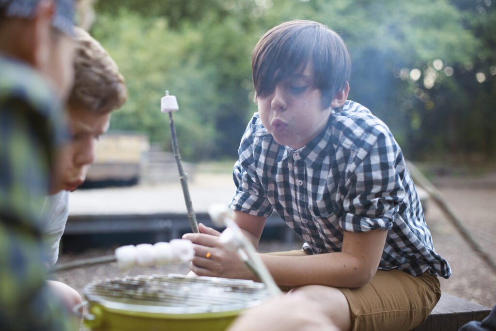 Tieners die marshmallows aan het roosteren zijn tijdens een bbq workshop